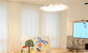 motorized curtains in a comfy den with fireplace and TV